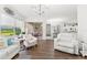 Open-concept living room featuring hardwood floors, white furniture, and a dining area with outdoor access at 1205 Draycott St, Ormond Beach, FL 32174