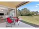 A cozy outdoor patio with table and chairs, adjacent to lush backyard and living area at 1205 Draycott St, Ormond Beach, FL 32174