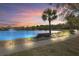 Scenic pond view with a tranquil fountain and bench at sunset, inviting residents to unwind and enjoy the peaceful surroundings at 1205 Draycott St, Ormond Beach, FL 32174