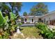 Relaxing backyard showing deck with pond, statues, and mature, tropical landscaping at 1254 Mardrake Rd, Daytona Beach, FL 32114