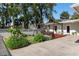 Charming backyard featuring a wooden deck with pergola and chairs overlooking a serene pond at 1254 Mardrake Rd, Daytona Beach, FL 32114