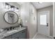 Updated bathroom features granite counters and a round decorative mirror at 1254 Mardrake Rd, Daytona Beach, FL 32114