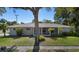 Charming home with a well-maintained lawn, mature tree, and inviting screened front porch at 1254 Mardrake Rd, Daytona Beach, FL 32114