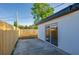 Backyard patio featuring a wood fence, grass and the exterior of the home with a sliding glass door at 1304 Genmar St, Daytona Beach, FL 32117