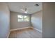 Bright bedroom with wood-look flooring, a ceiling fan, and two windows providing ample natural light at 1304 Genmar St, Daytona Beach, FL 32117