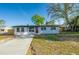 Beautiful single-story home with a well-manicured lawn, mature trees, and a paved driveway leading to the front entrance at 1304 Genmar St, Daytona Beach, FL 32117