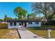 Charming home featuring a fresh exterior, vibrant red door, and newly paved driveway at 1304 Genmar St, Daytona Beach, FL 32117