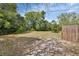 Large backyard with mature trees and a wood fence at 1434 Deltona Blvd, Deltona, FL 32725
