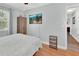 Neutral bedroom featuring wood floors, TV, and a side table with wicker drawers at 1434 Deltona Blvd, Deltona, FL 32725