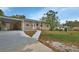 Home exterior featuring a welcoming front entrance, carport, and well-manicured lawn at 1434 Deltona Blvd, Deltona, FL 32725