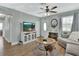 Cozy living room featuring wood-look flooring, a ceiling fan, and a view of the front door at 1434 Deltona Blvd, Deltona, FL 32725