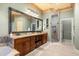 Elegant bathroom featuring a double vanity with granite countertop, a large mirror, and a walk-in shower at 1450 Shady Meadow Ln, Deland, FL 32724