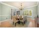 An open dining room features hardwood floors, natural light, and elegant chandelier at 1450 Shady Meadow Ln, Deland, FL 32724