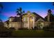 Elegant two-story home at dusk, boasting lush greenery and a beautifully illuminated facade at 1450 Shady Meadow Ln, Deland, FL 32724