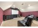 A cozy media room with a projector screen, comfortable seating, and dark red walls at 1450 Shady Meadow Ln, Deland, FL 32724