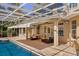 A covered outdoor living space with a brick patio, comfortable seating and a view of the pool at 1450 Shady Meadow Ln, Deland, FL 32724