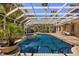 A screened-in pool area with a tanning ledge, spa, lush landscaping and brick pavers at 1450 Shady Meadow Ln, Deland, FL 32724