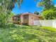 Brick home with mature landscaping and white privacy fence at 1490 Kettledrum Trl, Enterprise, FL 32725