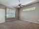 Neutral bedroom with a ceiling fan, carpet flooring, and natural light from two windows at 1490 Kettledrum Trl, Enterprise, FL 32725