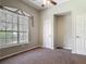 Bedroom with neutral walls, a ceiling fan, a large window, and a closet at 1490 Kettledrum Trl, Enterprise, FL 32725