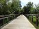 A wooden bridge spans a lush green landscape, offering a tranquil walking path through nature at 1490 Kettledrum Trl, Enterprise, FL 32725