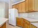 Bright kitchen with wooden cabinets, light countertops, and a modern refrigerator at 1490 Kettledrum Trl, Enterprise, FL 32725