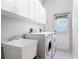 Laundry room featuring a utility sink, washer, dryer, and ample storage cabinets at 1490 Kettledrum Trl, Enterprise, FL 32725