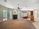 Spacious living room featuring carpet, a fireplace, and large windows with natural light at 1490 Kettledrum Trl, Enterprise, FL 32725