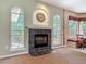 A living room with a fireplace, neutral walls, and large windows at 1490 Kettledrum Trl, Enterprise, FL 32725