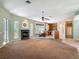Spacious living room featuring a fireplace, large windows, and seamless flow into the kitchen and dining area at 1490 Kettledrum Trl, Enterprise, FL 32725