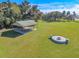Aerial shot of a pavilion and firepit on a sprawling green lawn, perfect for outdoor gatherings and relaxation at 1490 Kettledrum Trl, Enterprise, FL 32725