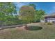 Manicured backyard featuring a trimmed shade tree, privacy fence, and view of the screened in porch at 1512 Lancashire Way, Deland, FL 32720