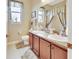 This bathroom features double sinks, and two windows with curtains at 1512 Lancashire Way, Deland, FL 32720