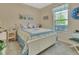 This bedroom features a blue and white quilt, a window with blinds, and light neutral walls at 1512 Lancashire Way, Deland, FL 32720