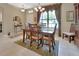 Elegant dining area featuring tile flooring, large window with decorative curtains, and a cozy ambiance at 1512 Lancashire Way, Deland, FL 32720
