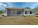 Rear exterior view showcasing screened-in patio with outdoor seating, plus an expansive lawn at 1512 Lancashire Way, Deland, FL 32720