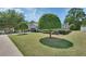 Landscaped front yard featuring a trimmed shade tree and lush green grass at 1512 Lancashire Way, Deland, FL 32720