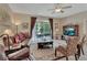 Comfortable living room featuring a ceiling fan, sliding glass doors, and neutral color palette at 1512 Lancashire Way, Deland, FL 32720