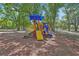 Community playground with a slide, climbing structures, and a shade tree at 1512 Lancashire Way, Deland, FL 32720