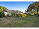 Expansive backyard featuring a screened-in patio, lush landscaping, and ample space for outdoor activities and relaxation at 1540 Park Forest Blvd, Mount Dora, FL 32757