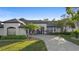 Beautiful single-story home features a white painted brick exterior, black trim, landscaping, and a curved driveway at 1540 Park Forest Blvd, Mount Dora, FL 32757