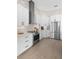A modern kitchen featuring white cabinets, stainless steel appliances, and light wood flooring at 1540 Park Forest Blvd, Mount Dora, FL 32757