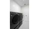 Modern laundry room features a front-loading washer and dryer set, and subway tile wall at 1540 Park Forest Blvd, Mount Dora, FL 32757
