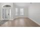 A bright living room features neutral paint, an elegant front door, hardwood floors, and large windows at 1540 Park Forest Blvd, Mount Dora, FL 32757