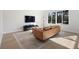 A cozy living room features a comfortable tan leather sofa, a flat-screen television, and bright natural light at 1540 Park Forest Blvd, Mount Dora, FL 32757