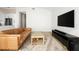 An open concept living room with a tan leather sofa, a large flat-screen television, and light wood flooring at 1540 Park Forest Blvd, Mount Dora, FL 32757