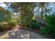 Landscaped backyard with mature trees, stone patio, and lush plantings, creating a peaceful and private outdoor space at 1628 Bent Oaks Blvd, Deland, FL 32724