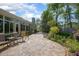Beautiful backyard featuring stone patio, sunroom, and well-manicured landscaping at 1628 Bent Oaks Blvd, Deland, FL 32724