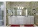 Bathroom featuring wallpaper, double vanity, and mirrors at 1628 Bent Oaks Blvd, Deland, FL 32724