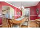 Open-concept dining room showcases the hardwood floors, chandelier, and adjoining rooms at 1628 Bent Oaks Blvd, Deland, FL 32724